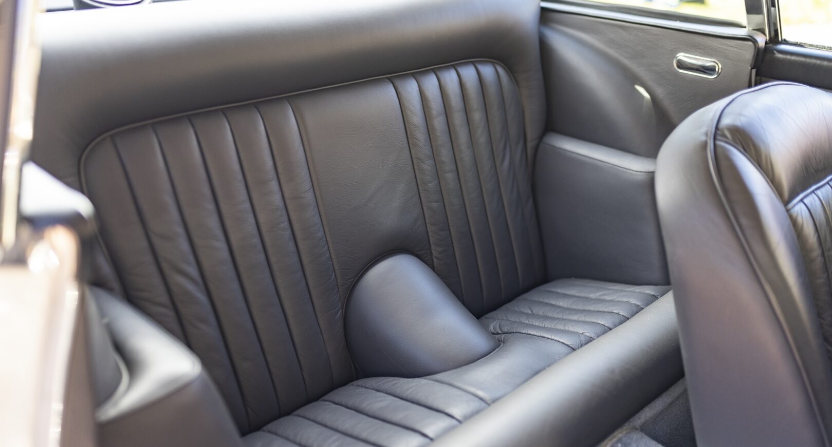 Rear seats of silver Aston Martin DB5