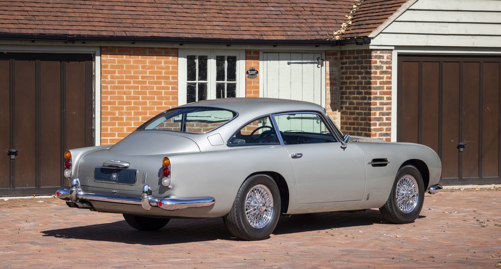 Rear three quarter view of silver Aston Martin DB5